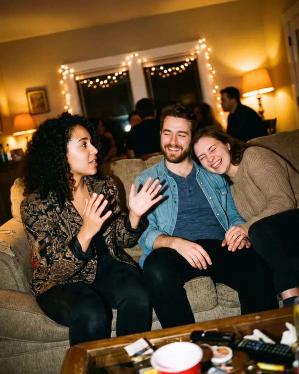 Friends laughing on a sofa, seen through the camera.
