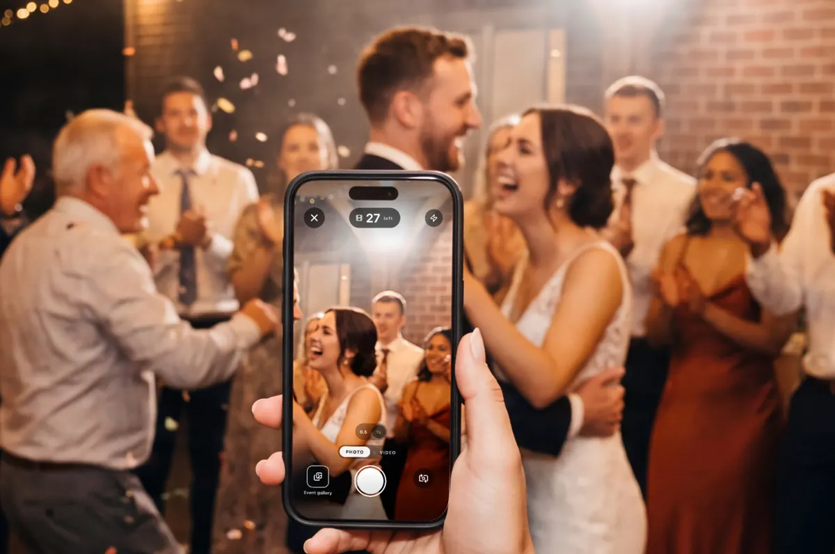 A guest holds up her phone on a crowded dance floor; the AllShots camera on its screen shows 27 shots left.